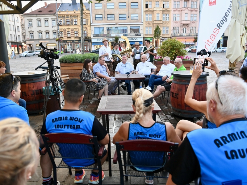 Musiker. Im Hintergrund Personen vor Stadtkulisse