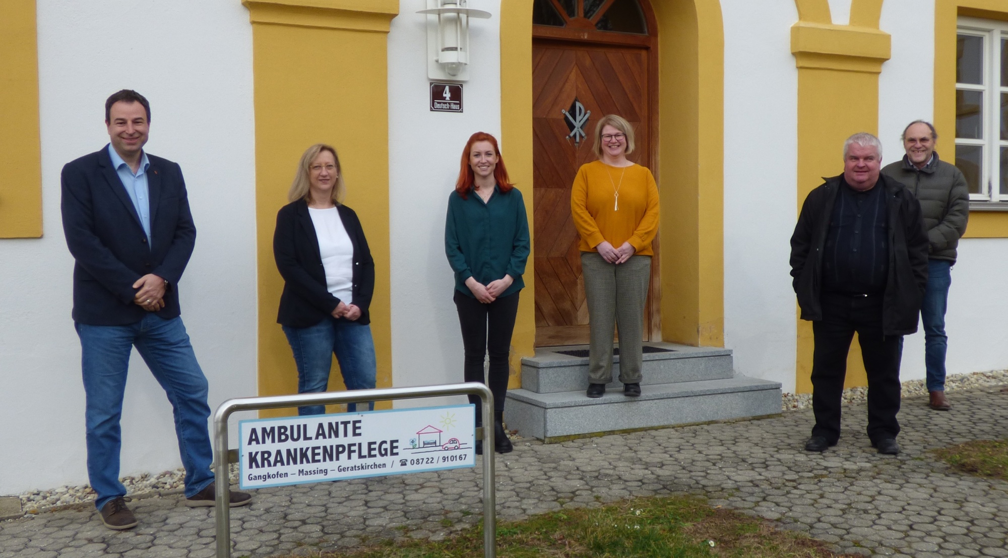 Sechs Personen vor einem Gebäude