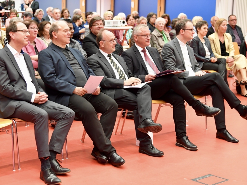 Personen auf St&uuml;hlen h&ouml;ren zu