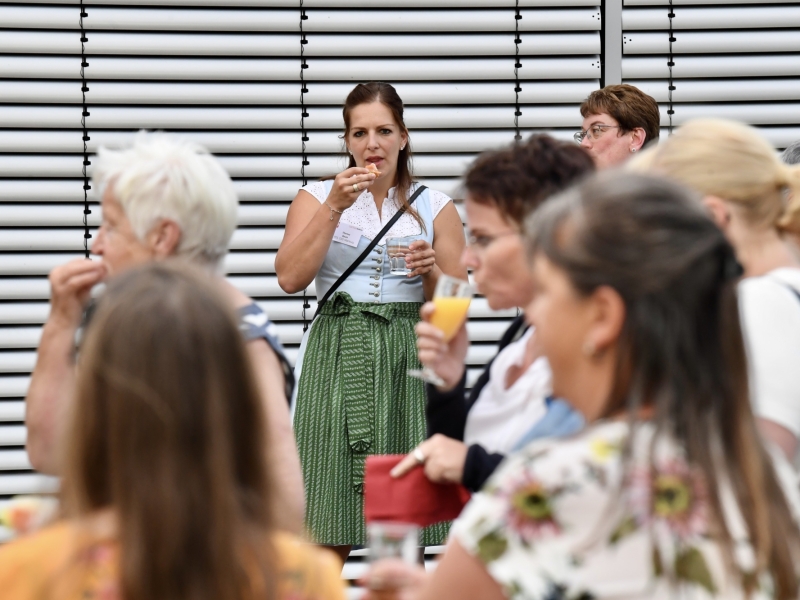 Personen unterhalten sich aneinem Stehtisch
