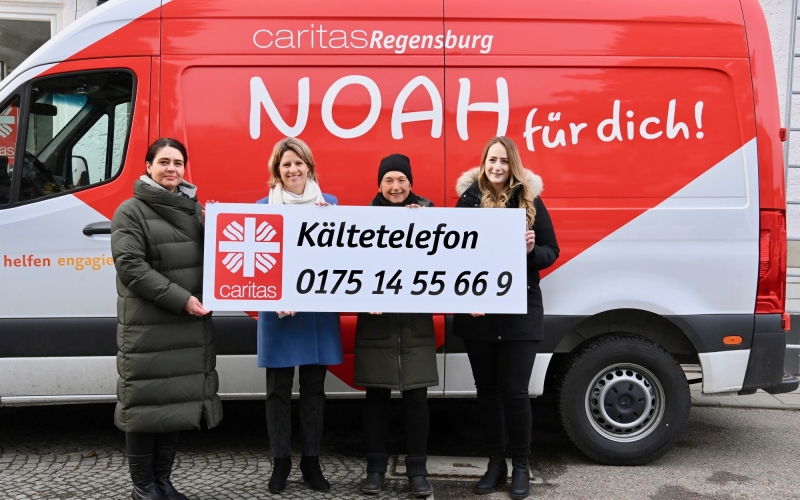Vier Personen vor rotem Bus