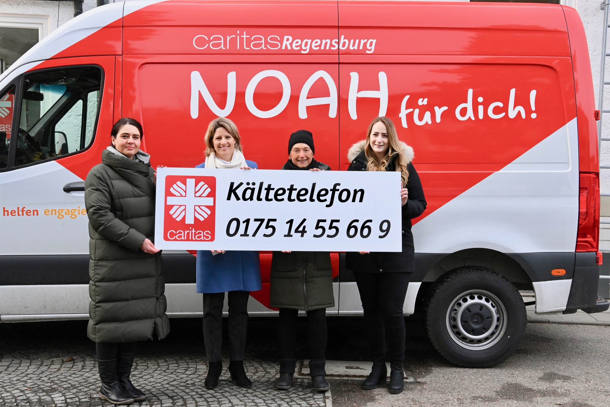 Vier Personen vor rotem Bus