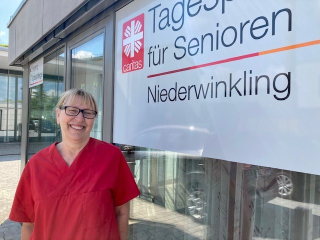 Frau vor Seniorenheim