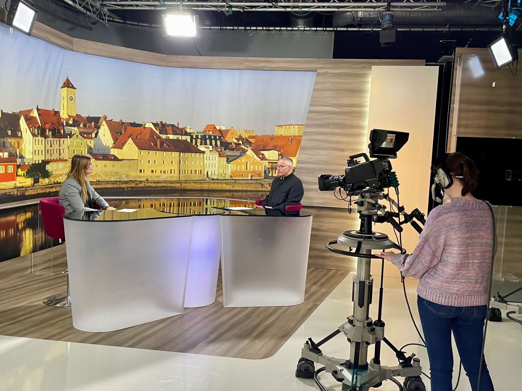 Zwei Personen sitzen sich im Studio gegenüber und führen offenbar ein Gespräch.