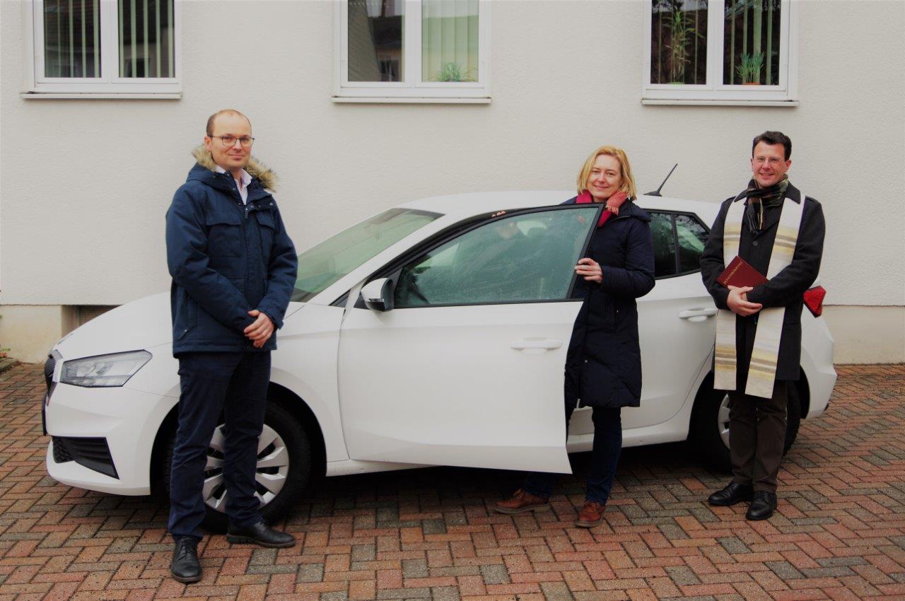 3 Personen vor einem Auto