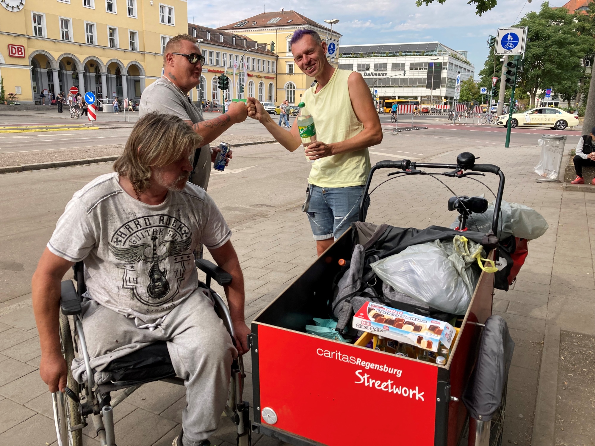 Drei Personen mit Lastenrad
