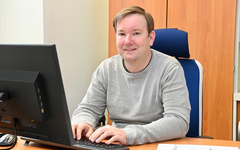 Mann am Tisch hinter Computer