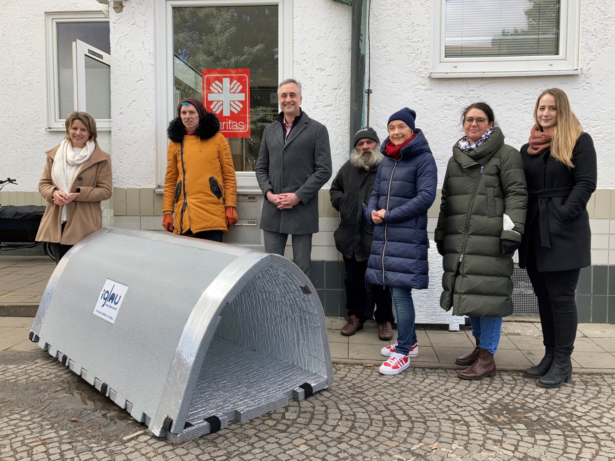 7 Personen hinter Iglu