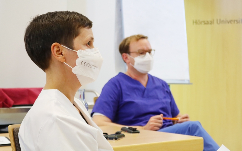 Zwei Personen mit Masken