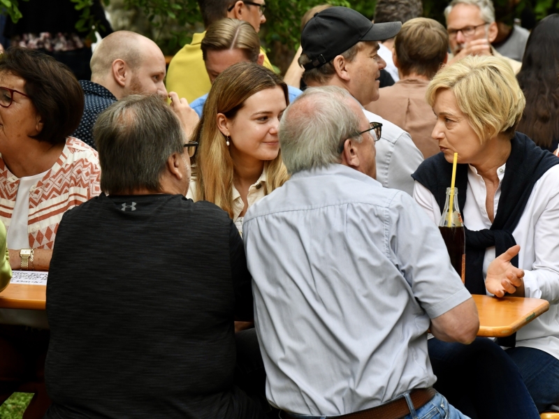 Personen im Garten an Bierb&auml;nken