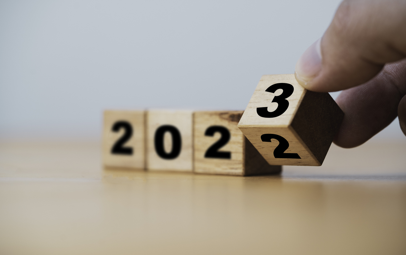Eine Hand dreht Holzwürfel von 2022 auf 2023