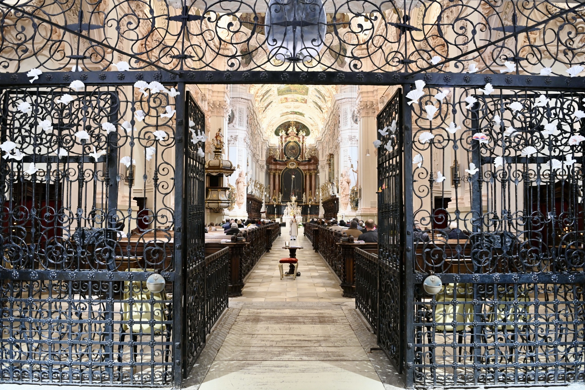Geistlicher läuft durch die Reihen in Kirche