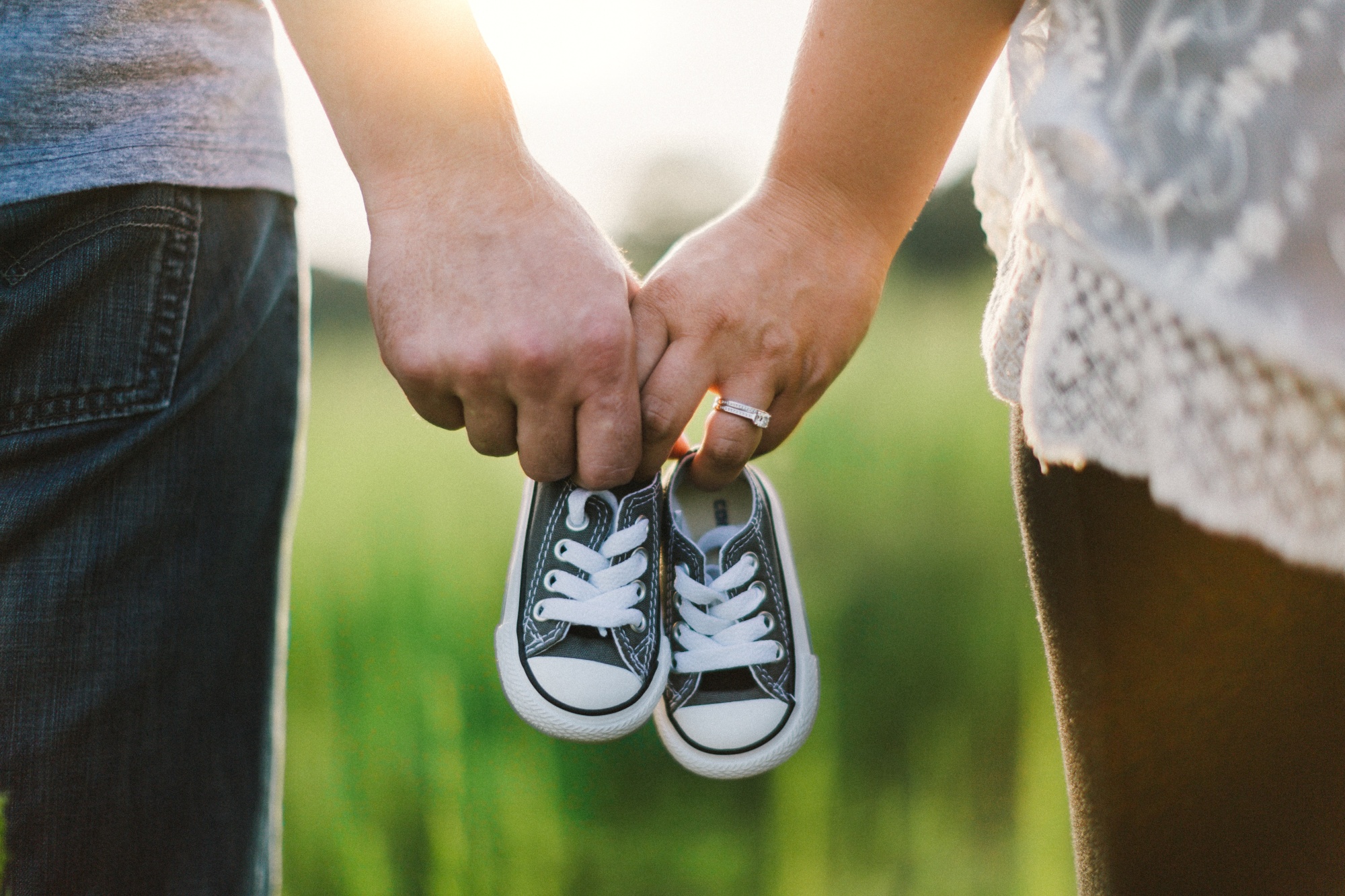 Zwei Personen halten Kinderschuhe in der Hand