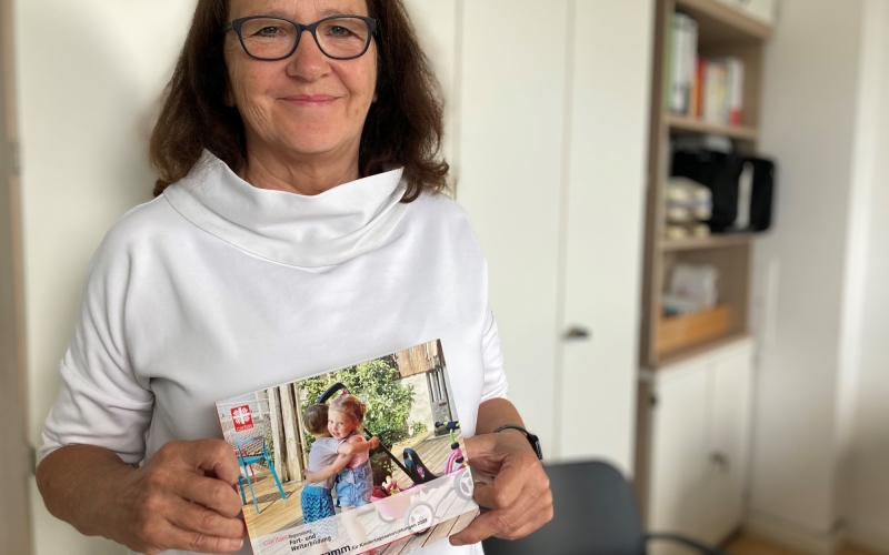 Frau hält Flyer in der Hand